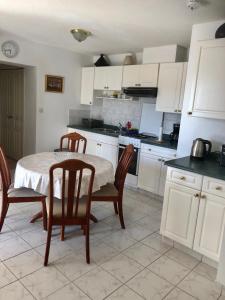 a kitchen with a table and chairs and a kitchen with white cabinets at Apartment Hannah in Brna +10 photos
