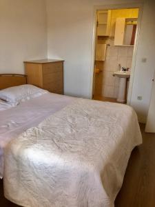 1 Schlafzimmer mit einem weißen Bett und einem Badezimmer in der Unterkunft Apartment Hannah in Brna