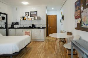 サラマンカにあるEstudio en la calle mas bonita de salamancaのベッドとテーブルとキッチンのある寝室
