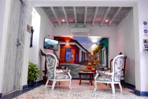 un pasillo con 2 sillas y TV en una habitación en Hotel Boutique Callecitas de San Diego, en Cartagena de Indias