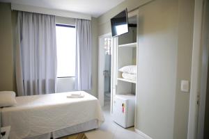 a small bedroom with a bed and a window at Hotel Emacite Flex in Mafra