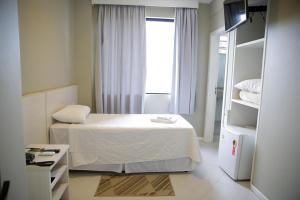 a small bedroom with a bed and a window at Hotel Emacite Flex in Mafra