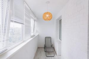 a chair in a hallway with a window and a chandelier at Apart-Hotel in Sumy +1 photo