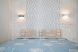 a bedroom with a blue bed with two pillows at Apart-Hotel in Sumy