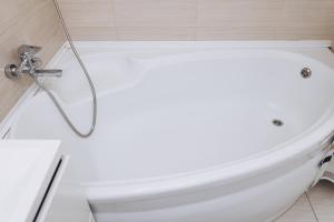a white bath tub in a bathroom with a toilet at Apart-Hotel in Sumy