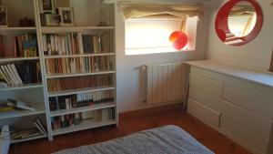 a room with a window and book shelves with books at Atico Playa Fontaiña in Vigo