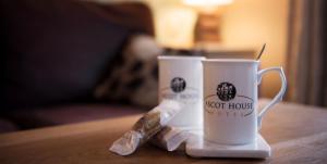two coffee cups sitting on top of a table at Ascot House Hotel in Torquay
