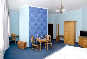 a room with a table and chairs and a blue wall at Hotel & Restaurant Haus am See in Löcknitz