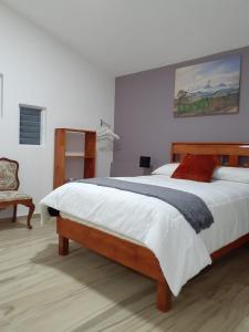 una camera con un grande letto e una sedia di ANBAROA VILLAS a Tlaxcala de Xicohténcatl
