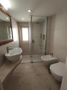 łazienka z 2 umywalkami, prysznicem i toaletą w obiekcie Taormina House w Taominie