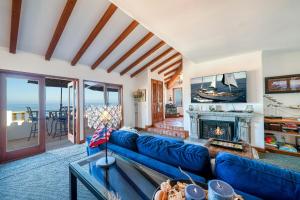 a living room with a blue couch and a fireplace at Gorgeous Oceanfront Villa With Panoramic Views in Avalon