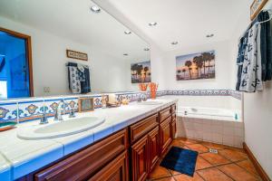 ein Badezimmer mit zwei Waschbecken und einer Badewanne in der Unterkunft Gorgeous Oceanfront Villa With Panoramic Views in Avalon