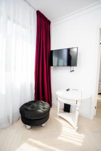 a living room with a black ottoman and a table and red curtains at Apartament Amaya in Bistriţa
