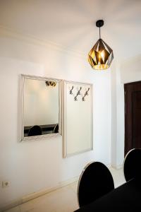a dining room with a mirror and a chandelier at Apartament Amaya in Bistriţa