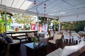 a patio with couches and chairs and a table at Pousada Canto das Pedras in Bombinhas