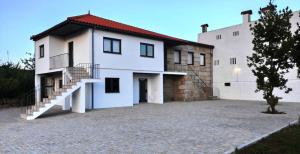 a white house with a staircase in front of it at Green Garden Houses in Chaves