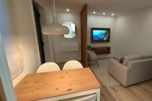 a living room with a table and a couch at Green Garden Houses in Chaves