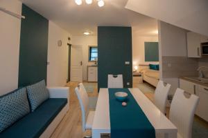 a kitchen and living room with a table and chairs at Égerliget Vendégház in Harkány