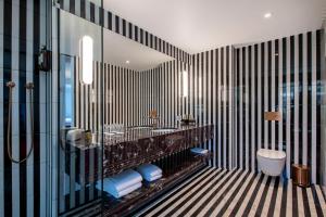 a bathroom with a black and white striped wall at Bazzar Boutique Hotel in Tbilisi City