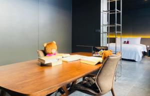 a teddy bear sitting on a table with books at Orient Luxury Villa Motel in Huwei