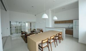 a kitchen with a large wooden table and chairs at iFlat Gift Home Oeste in Goiânia