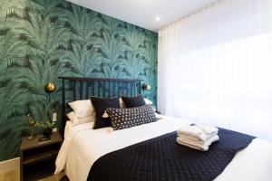 una camera con un letto con una parete verde di Blue Tropics Studio in Little Italy with kitchen by Den Stays a Montréal