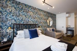 - une chambre dotée d'un lit avec du papier peint bleu et blanc dans l'établissement Sunny Green Palms Micro Studio with Yard View by Den Stays, à Montréal