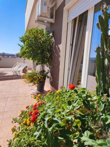 a balcony with flowers on the side of a house at IsolaAzzurra in Monopoli