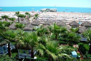 クンドゥにあるデルフィン ディーバ プルミエールのヤシの木と傘が備わるビーチの景色を望めます。