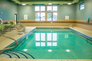 een zwembad in een gebouw met blauw water bij Holiday Inn Express & Suites - Worthington, an IHG Hotel in Worthington