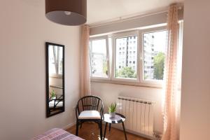 1 dormitorio con silla y ventana en Mary's apartment - with free parking en Zagreb