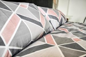 un letto con cuscini bianchi e neri sopra di Pink Sapphire Double Room with En-suite & Wifi a Derby