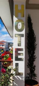 a sign that says hotel next to a plant at Hotel Lili - Popayán in Popayan