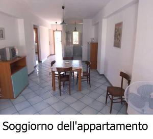 cocina y comedor con mesa y sillas en Appartamento a pochi passi dal mare, en Canneto