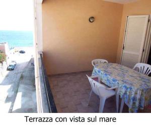 un tavolo e sedie su un balcone con vista sull'oceano di Appartamento a pochi passi dal mare a Canneto
