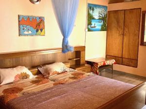 una camera da letto con un letto con una tenda blu sopra di Jungle Beach Resort a Sanyang