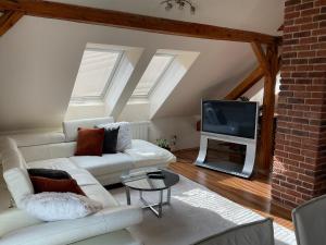 een woonkamer met een witte bank en een tv bij Apartmany Rosna in Košice