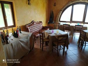 a restaurant with two tables and chairs with wine bottles on them at Antico Borgo di Albe in Albe