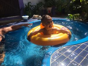 a young boy in a raft in a swimming pool at Pousada da Lucinha in Canoa Quebrada