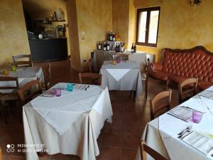 ein Restaurant mit 2 Tischen und weißem Tischtuch in der Unterkunft Antico Borgo di Albe in Albe