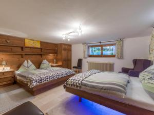 Un dormitorio con 2 camas y una silla. en Exclusive Villa Tirol, en Fieberbrunn