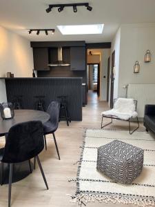 uma sala de estar com mesa e cadeiras e uma cozinha em Unique luxury apartment with cosy garden! em Gent