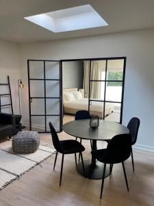 sala de estar con mesa, sillas y cama en Unique luxury apartment with cosy garden! en Ghent
