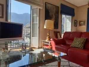 un soggiorno con divano rosso e TV di Alojamiento Cazorla Visión a Cazorla