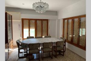 a dining room with a table and chairs and a chandelier at Casa rural con piscina / Cottage house with swimming pool in Elche