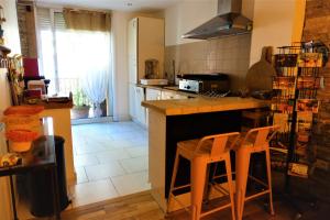 a kitchen with a counter and two chairs in it at Maison Small Luxury ( planxa,suite,solarium,jacuzzi,pas de vis à vis) in Argelès-sur-Mer