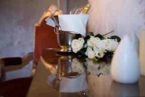 un tavolo con un vaso con fiori bianchi di Ca Dell'Arte a Venezia