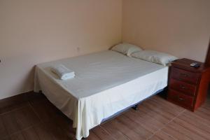 a small bedroom with a bed and a nightstand at Apartamentos y Hostal RUDON #1 in Puerto Cortes