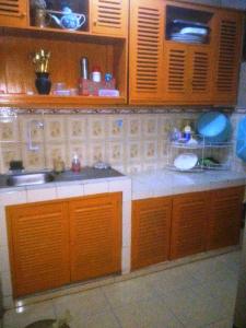 a kitchen with wooden cabinets and a sink at Guest House Dissa in Purwokerto