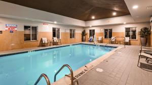una piscina en un hotel con sillas y mesas en Best Western Plus New Cumberland, en New Cumberland